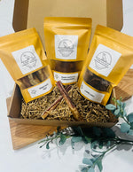 Small dog sniffing the Tiny Tails Box filled with natural, single-ingredient treats made for puppies and small breeds.