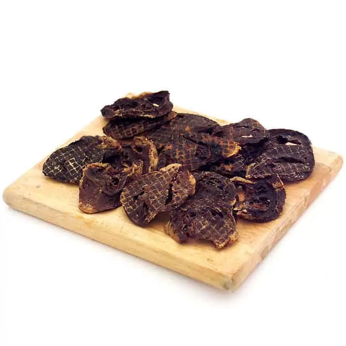 A wooden board with dehydrated beef heart chips.